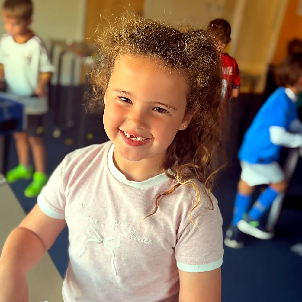 A girl smiling during an indoor camp session